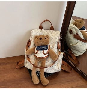 Detail of cute bear printed backpack with a plush 3D teddy bear pendant decoration