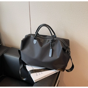 Close-up of a durable black travel bag with PU leather accents and smooth nylon texture
