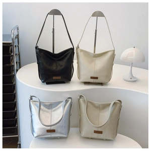 Close-up of hobo shoulder bags in black, cream, silver, and green on display