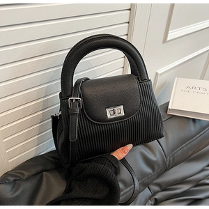 Detail of black quilted leather crossbody bag with silver twist lock and handle