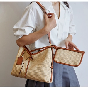 Détail du sac cabas en paille tissée avec garniture en cuir marron et pochette assortie