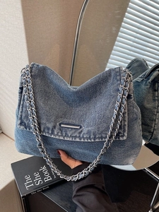 Blue denim shoulder bag with silver chain straps and metallic bar detail for women