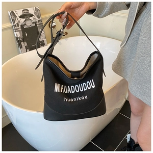 Detail of black canvas bucket bag with logo print and reinforced leather bottom