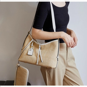 Détail du sac cabas en paille tissée avec bordure en similicuir blanc et pochette assortie