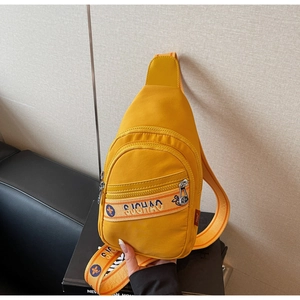 Gros plan du sac à bandoulière jaune gingembre avec sangle contrastée et détails