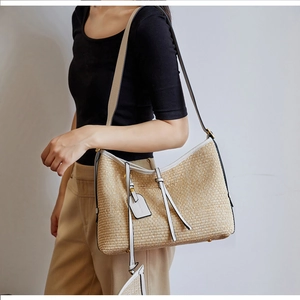 Détail du tissage en paille et bordure en cuir crème sur le sac cabas rayé
