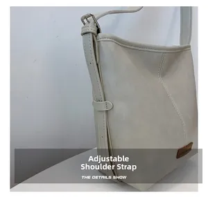 Detail of adjustable shoulder strap and beige matte leather texture on a hobo bag
