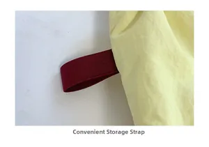 Detail showing the convenient dark red elastic storage strap on the yellow canvas tote
