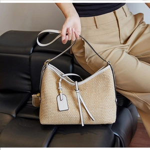 Gros plan détaillé du sac cabas en paille tissée avec finitions en cuir blanc et doré