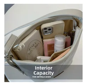 Internal view of cream leather bucket bag showing spacious storage with a zipper pocket
