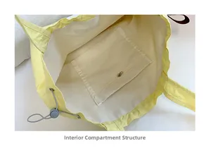 Detail view of the drawstring yellow canvas tote showing inner lining and zipper pocket