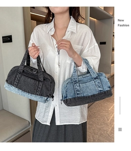 Close-up of two-tone denim cylinder bag with contrast stitching and dual handle straps
