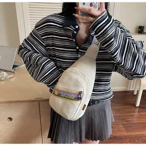 Détail du sac de poitrine en toile crème avec lettrage Suchao et sangles colorées