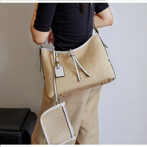 Détail du sac à bandoulière en paille tressée avec bordure en cuir blanc et pochette