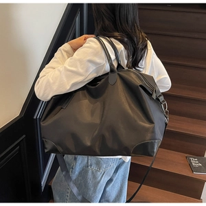 Detail of waterproof nylon travel bag with reinforced leather corners and shoulder strap