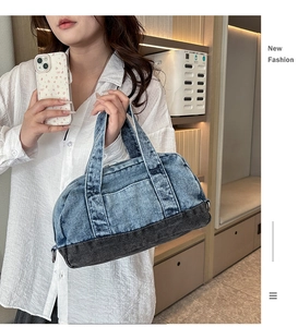 Detail of color-block denim barrel bag showing washed fabric texture and sturdy handles