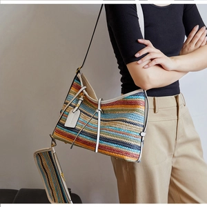 Détail du sac cabas tissé à rayures bohèmes avec lanières en cuir blanc et pochette