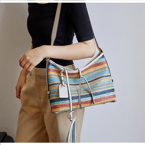 Détail du sac bandoulière tissé à rayures colorées avec bandoulière en cuir blanc
