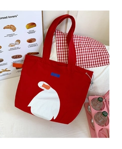 Detail of red canvas tote bag with white goose print and side drawstring buckle