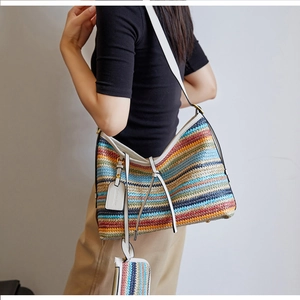 Détail du sac cabas tissé à rayures multicolores avec bandoulière en cuir blanc et pochette