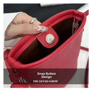 Détail du sac seau rouge en cuir grainé avec mécanisme de fermeture magnétique pratique