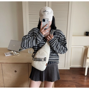 Détail du sac bandoulière en toile blanc cassé avec sangles lettrées SJCHAO dans un décor de maison