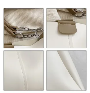 Close-up of minimalist white tote bag showing detailed stitching and khaki leather straps