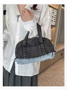 Close-up of dual-tone denim tote bag featuring vintage grey and washed blue stitching