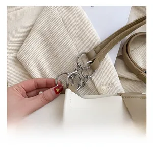 Detail view of silver multi-ring hardware and stitching on dual-tone tote bag
