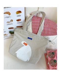 Close-up of cute duck illustration and Dazui duck label on a beige canvas tote bag