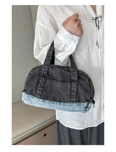 Detailed view of bicolor denim boston bag with top zipper and double handles