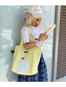 Detail of cute white duck print on large capacity yellow canvas tote bag for students