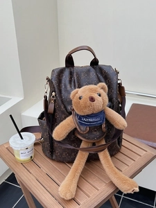Brown printed large capacity backpack featuring a teddy bear pattern and plush toy accessory