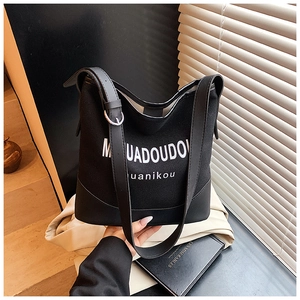 Detail of black canvas and leather bucket bag featuring white MUADOUDOU logo print