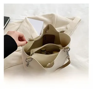 Detail showing the spacious interior of beige tote bag with a removable zipper pouch