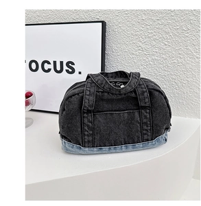 Detail of grey denim pillow bag with contrasting blue base and top zipper closure