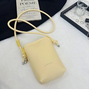 Détail du petit sac bandoulière jaune clair à motif litchi avec logo SUNWOMEN embossé