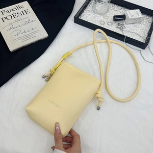 Détail du sac de téléphone en cuir crème texturé avec texte SUNWOMEN et bandoulière