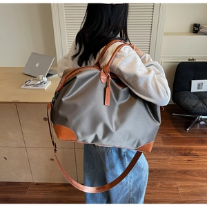 Close-up of durable grey canvas fabric with premium brown leather handles and strap