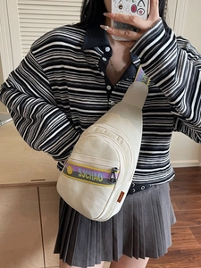 Sac bandoulière beige en toile avec surpiqûres contrastées et sangle réglable