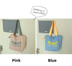 Detail großer Canvas-Tragetaschen in Rosa und Blau mit inspirierenden englischen Slogans