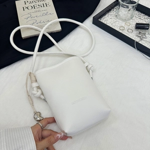 Vue détaillée du sac téléphone en cuir blanc avec breloque cœur argentée et nœud bandoulière