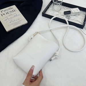 Détail d'un mini sac à bandoulière en cuir grainé blanc avec logo embossé et fine sangle corde