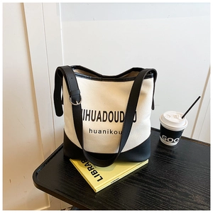 Detail of the large black and white canvas bucket bag with contrast leather trim