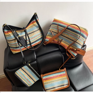 Détail d'un ensemble cabas tissé à rayures colorées avec pochette assortie sur un tabouret