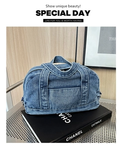 Detailed view of dark blue denim handbag texture and metal side buckle on fashion book
