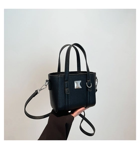 Dettaglio di una mini borsa a secchiello nera con dettagli argento e manico