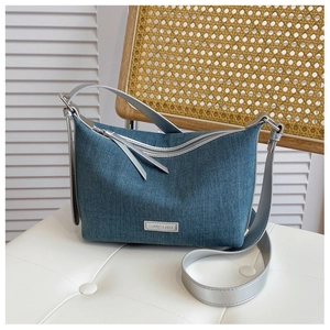 Dettaglio della borsa hobo in denim blu con manici metallici argento e logo