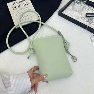 Vue détaillée du petit sac bandoulière vert clair texturé avec pendentif coeur
