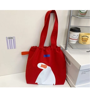 Detail of red canvas tote bag with drawstring closure and cartoon duck print design